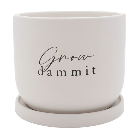 Round white matt ceramic planter with "Grow dammit" in black script and lower-case lettering, curved sides and matching saucer, on a plain white background.