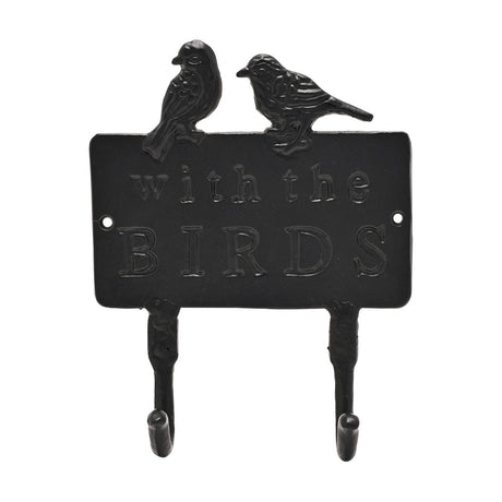 Black cast iron double wall hook with two perched birds atop a rectangular plaque reading "with the BIRDS" in raised lettering, two curved hooks below, shown on a plain white background.
