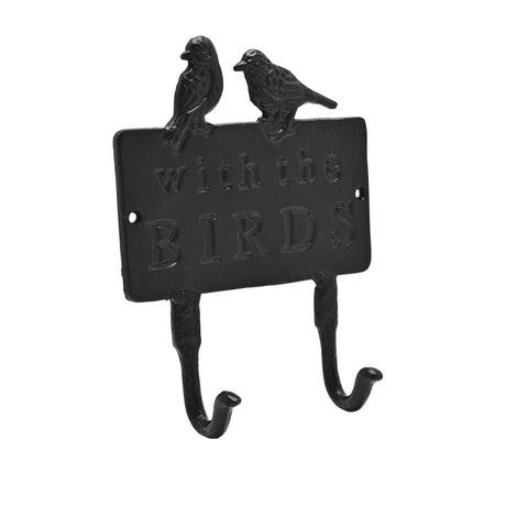 Black cast iron double wall hook with two perched birds atop a rectangular plaque reading "with the BIRDS", featuring two curved hooks below, shown on a plain white background.
