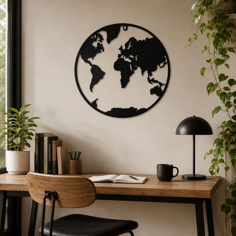 Circular World Map Silhouette Metal Wall Art, 40cm black cut-out design within a slim round border, displayed above a wooden desk in a home office setting.