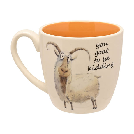 White earthenware mug with an illustrated shaggy goat and "you goat to be kidding" text, orange glazed interior, white C-shaped handle, on a plain background.