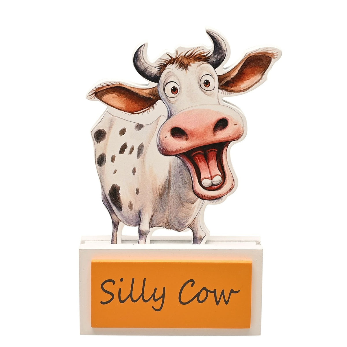 Wooden standing plaque cut to a cartoon cow's outline with spotted white coat, pink nose and grey horns, on a white base with an orange "Silly Cow" panel, shown against a plain white background.