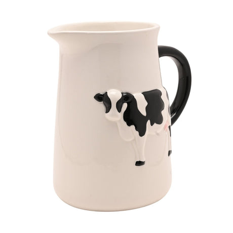 Cream earthenware jug with a raised black-and-white spotted cow design and curved black handle, shown on a plain white background.
