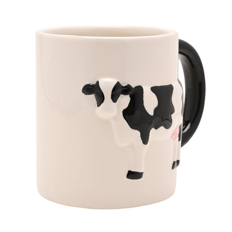 Cream earthenware mug with a raised black-and-white cow design in glossy relief and a rounded black gloss handle, shown on a plain white background.