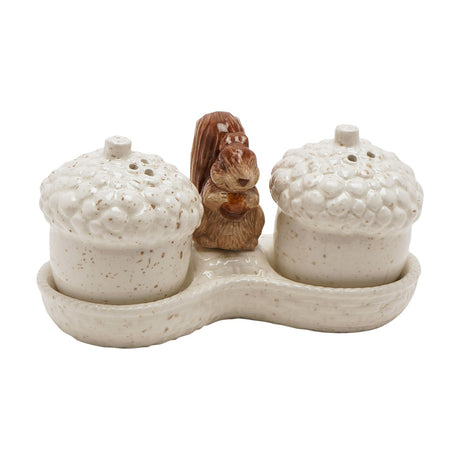 Cream ceramic salt and pepper set shaped as acorn shakers with textured caps, a brown squirrel figure between them, set on a matching curved tray, shown on a white background.