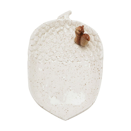 Speckled cream ceramic plate shaped like an acorn, with textured cup detailing, ribbed centre, short stalk, and a sculpted brown squirrel at the top, shown on a plain white background.