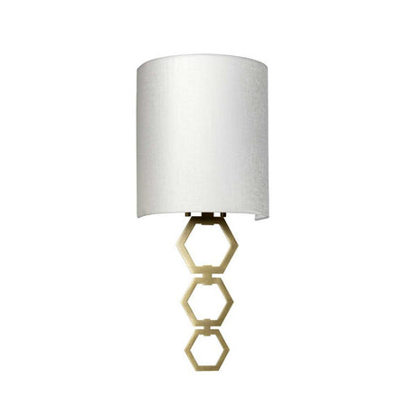 The Clark Small Wall Light - Aged Brass boasts a wall-mounted design, complete with a cylindrical faux silk shade and an elegantly decorative aged brass geometric support embellished with three connected hexagons.