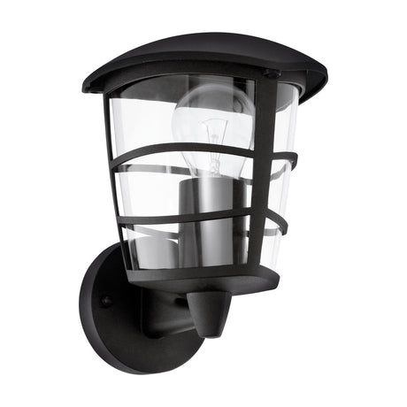 Clasvarne upward-facing outdoor wall light with black cast aluminium body, clear plastic shade with black banding, and visible E27 bulb, shown on a plain white background.
