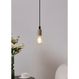 Clear LED globe bulb with visible filaments, E27 fitting, glowing warm white on a pendant light with wooden holder and black cable in a living room setting.