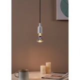 Clear Dimmable LED Reflector Bulb E27 R63 glowing warm white in a white pendant fitting above a styled desk with candles and a mug.