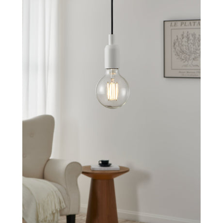 Clear LED globe bulb (E27, G95, 8W, warm white) with visible upright filaments, fitted to a white pendant hanging in a living room beside an armchair and side table.