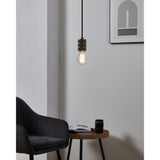 Clear LED GLS bulb, E27 fitting, glowing warm white in a pendant light fixture above a side table in a living room setting.