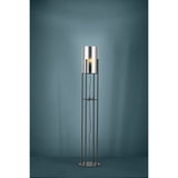 Clisvelle Floor Lamp in black steel, featuring four slim upright rods on a round base supporting a cylindrical vaporised glass shade with a visible E27 bulb, shown against a teal studio background.