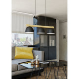 Clomenne Linear Pendant Light with three black dome shades on a wood-tone bar, hung above a glass coffee table in a living room setting.