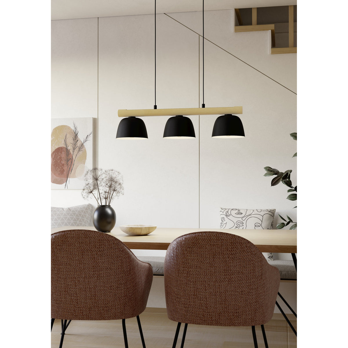 Clomenne Linear Pendant Light with three black dome shades on a wood-tone bar, suspended on black cords above a dining table in a living space.