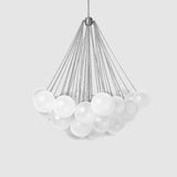 The Orb 17 Light Cluster Suspension - Silver features multiple frosted glass spheres elegantly suspended by metal cables from a central point, all against a plain light gray background.