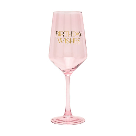 Pink glass stem wine glass with "BIRTHDAY WISHES" in gold lettering on the bowl, tapered shape and round foot, shown on a plain white background.