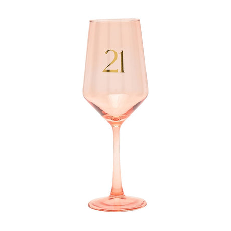 Peach-tinted stemmed wine glass with a gold "21" on the tapered bowl, slim stem, and round foot, shown on a plain white background.