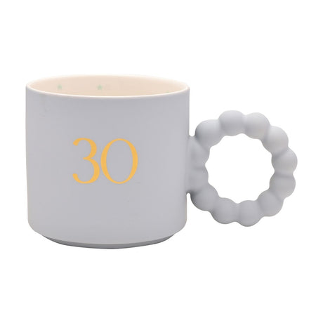 Blue porcelain mug with a gold "30" numeral, bobble ring handle, and cream star-patterned interior, shown on a plain white background.
