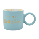 Light blue matt porcelain mug with "THE BEST grandad" in gold lettering, round handle, and a white and gold striped interior, shown on a plain white background.