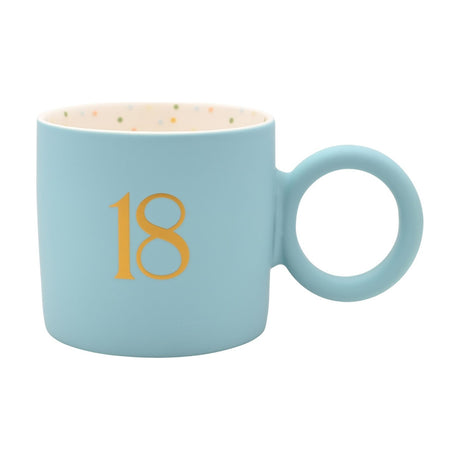 Pastel blue matte porcelain mug with round handle, gold "18" on front, cream interior speckled in green, blue, orange, yellow and pink.