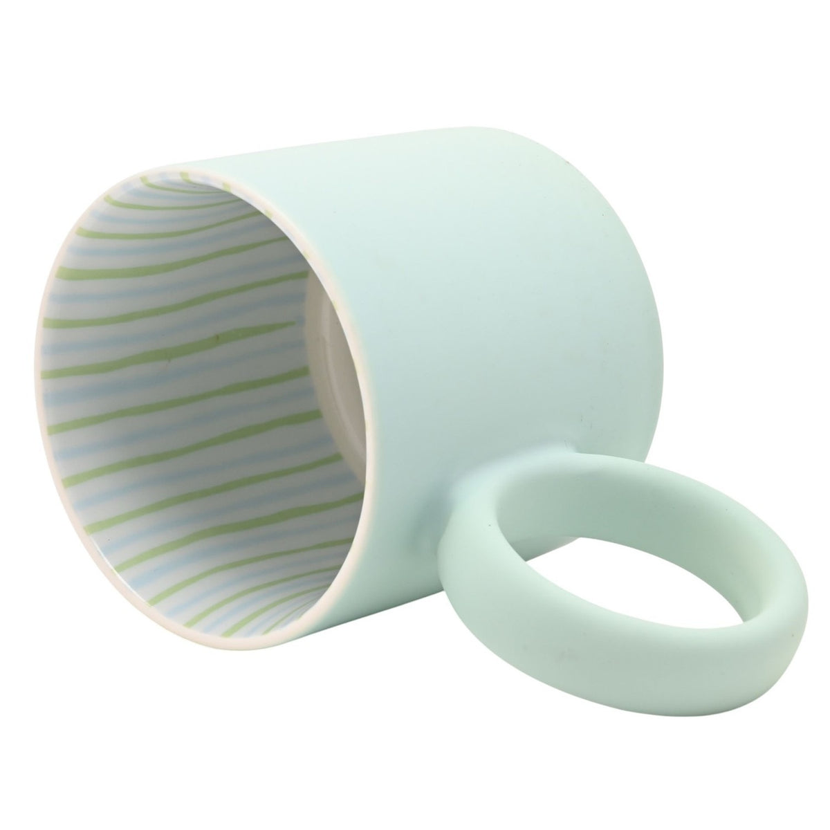 Matt porcelain mug in pale light blue with a round ring handle, tipped on its side to show the interior lined with thin green and pale blue stripes, on a plain white background.