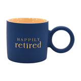 Matt porcelain mug in navy with "Happily retired" in gold lettering, a round navy ring handle, and a yellow interior dotted with small white spots, on a plain white background.