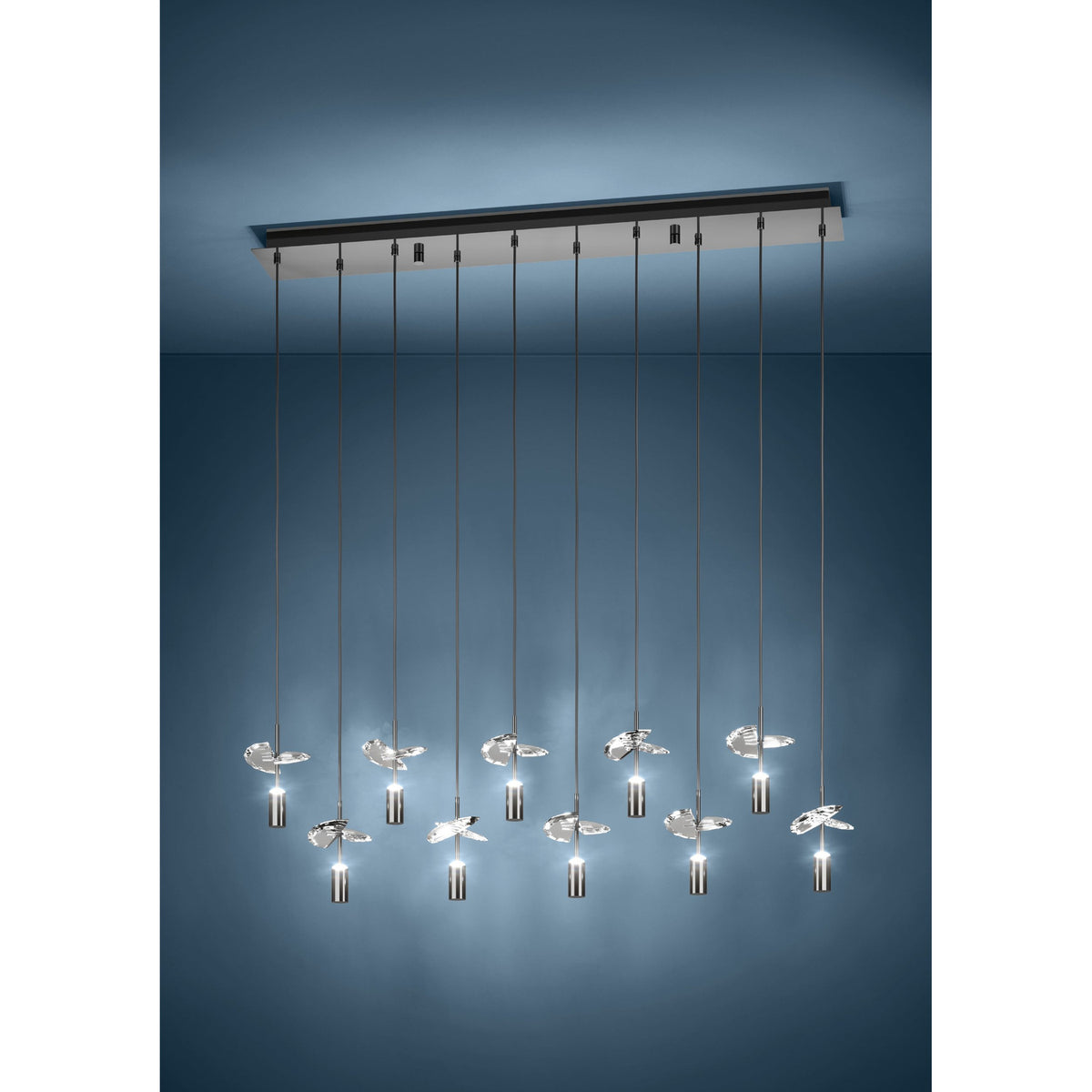 Comareira ten-light linear pendant in black nickel, with a long steel canopy, slim drops, cylindrical shades and clear faceted glass leaf details, shown against a dark blue studio background.