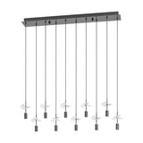 Comareira linear pendant light with a black nickel rectangular canopy and ten slim drops, each ending in a cylindrical shade with clear faceted glass leaf details, shown on a plain white background.