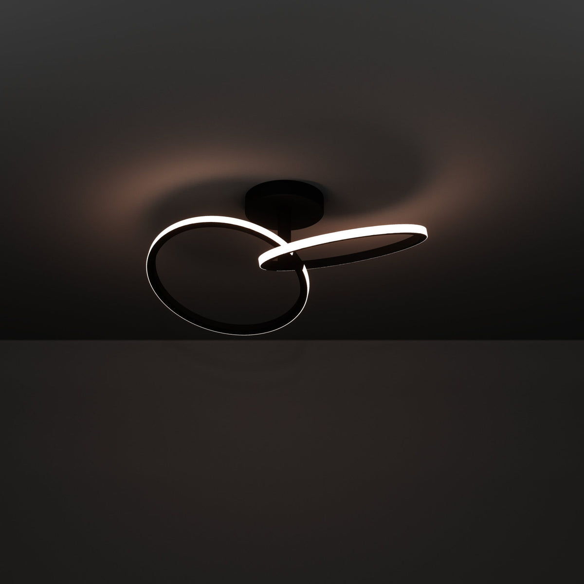 Congiunti LED Flush Ceiling Light in black steel, two interlinked illuminated rings with white diffusers on a round canopy, shown glowing against a dark background.