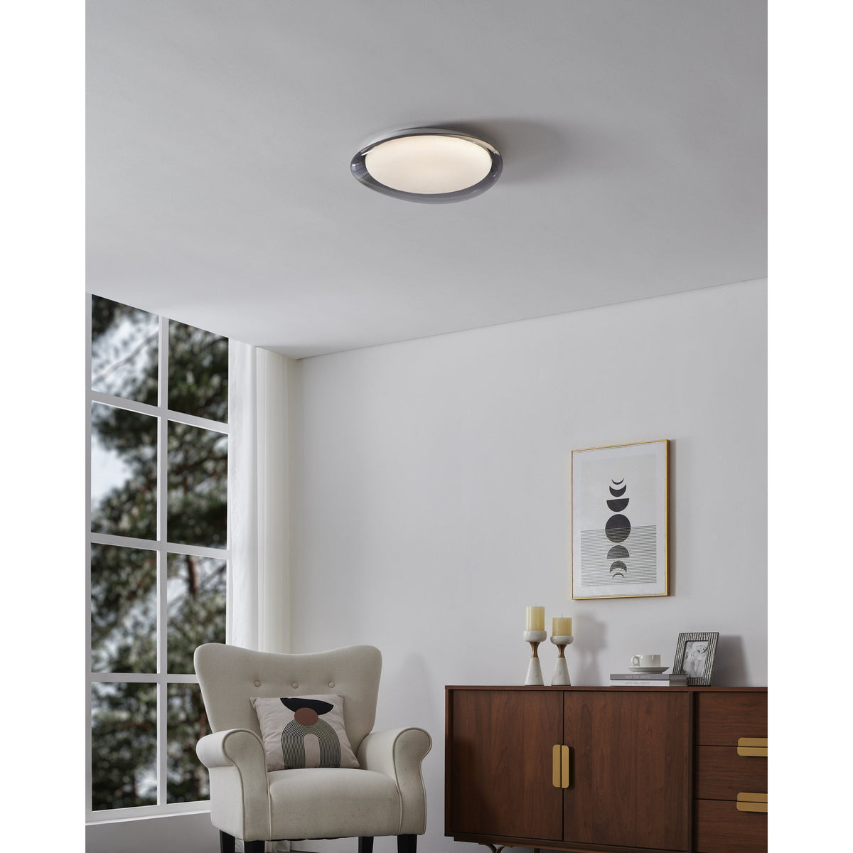 Conistarino LED Flush Ceiling Light 40cm in grey with white diffuser, fitted on a white ceiling in a living room above a beige armchair and wooden sideboard.