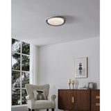Conistarino LED Flush Ceiling Light 40cm in grey with white diffuser, fitted on a white ceiling in a living room above a beige armchair and wooden sideboard.