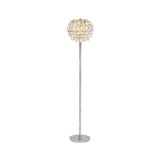 The Coniston 3 Light Crystal Floor Lamp in polished chrome features a tall, slim stand and a round shade with cascading crystal decorations, providing ambient lighting and a warm, soft glow.