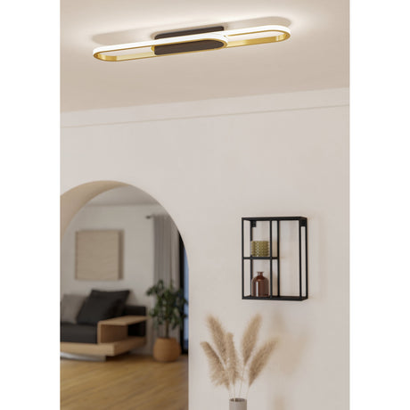 Conivarena LED flush ceiling light with black and brass overlapping loops and white diffuser edges, shown installed in a hallway with white walls and a wooden shelf.