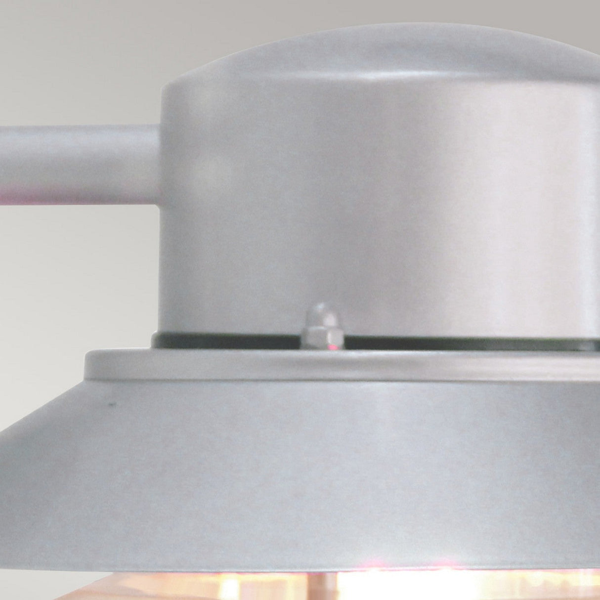 Close-up of a stainless steel overhead light fixture against a neutral background. This Copenhagen Outdoor Wall Lantern - Silver showcases Scandinavian design, featuring a cylindrical top and a conical bottom that beautifully directs light downward.