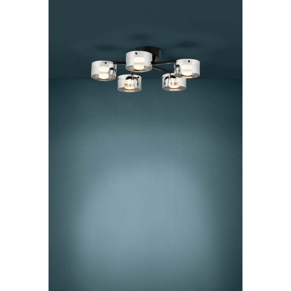 Copillos 5 Light Ceiling Light in black steel with five smoked glass cylindrical shades, mounted close to a dark teal ceiling and glowing warm white when lit.