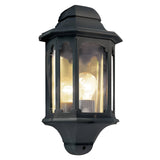 The Chapel-2 1 Light Outdoor Wall Lantern in black, constructed from durable die-cast aluminum, showcases an octagonal design with glass panels. It elegantly holds a single glowing light bulb against a simple white backdrop.