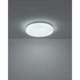 Crelvette round flush LED ceiling light with white steel body and crystal-effect plastic diffuser, illuminated on a grey ceiling in a room setting.
