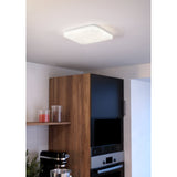 Crelvette square LED ceiling panel light in white, 33 x 33cm with crystal-effect diffuser, shown recessed-style on a kitchen ceiling above wooden cabinetry.