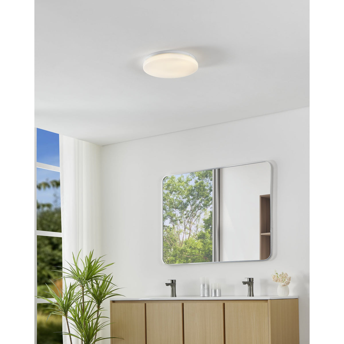 Crelvette LED Bathroom Ceiling Light 31cm in white, shown flush-mounted above a bathroom vanity with mirror, illuminating the space with a soft, even glow.