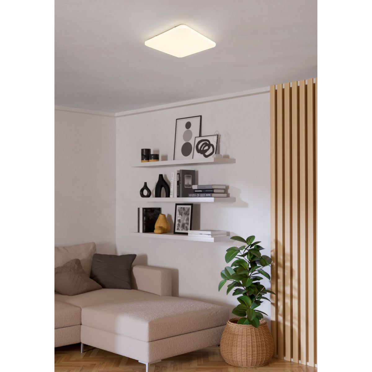 Crelvette 53 x 53cm square LED ceiling panel light in white, mounted flush on a living room ceiling above shelving, a sofa, and a potted plant.