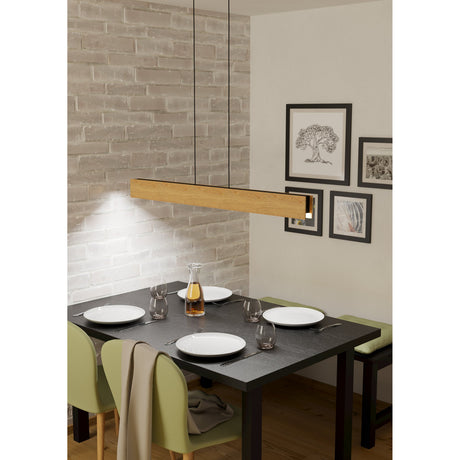 Crilmena Smart Colour Changing Pendant Light in a brown wood finish with black cables, shown as a slim rectangular bar above a dark dining table with framed art against a brick-effect wall.