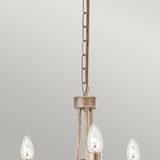 Close-up of the Christina 3 Light Chandelier - Silver/Gold Patina, featuring a metal chain and three candle-like bulbs, adorned with crystal drops and boasting a stunning Silver and Gold patina finish, set against a plain background.