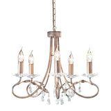 Introducing the Christina 5 Light Chandelier in Silver/Gold Patina, featuring a vintage style with five candle-shaped lights adorned with crystal drops. The chandelier boasts a bronze finish, elegantly curved metal arms, and hanging droplets, all suspended from a chain. The bulbs are designed to resemble flames, adding an elegant touch to this convertible design fixture.