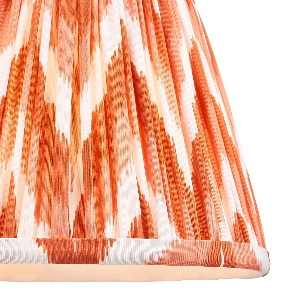 Endon Daneton 20cm tapered lamp shade in apricot orange and white, close-up of the pleated faux silk with zigzag print and taped bottom edge.