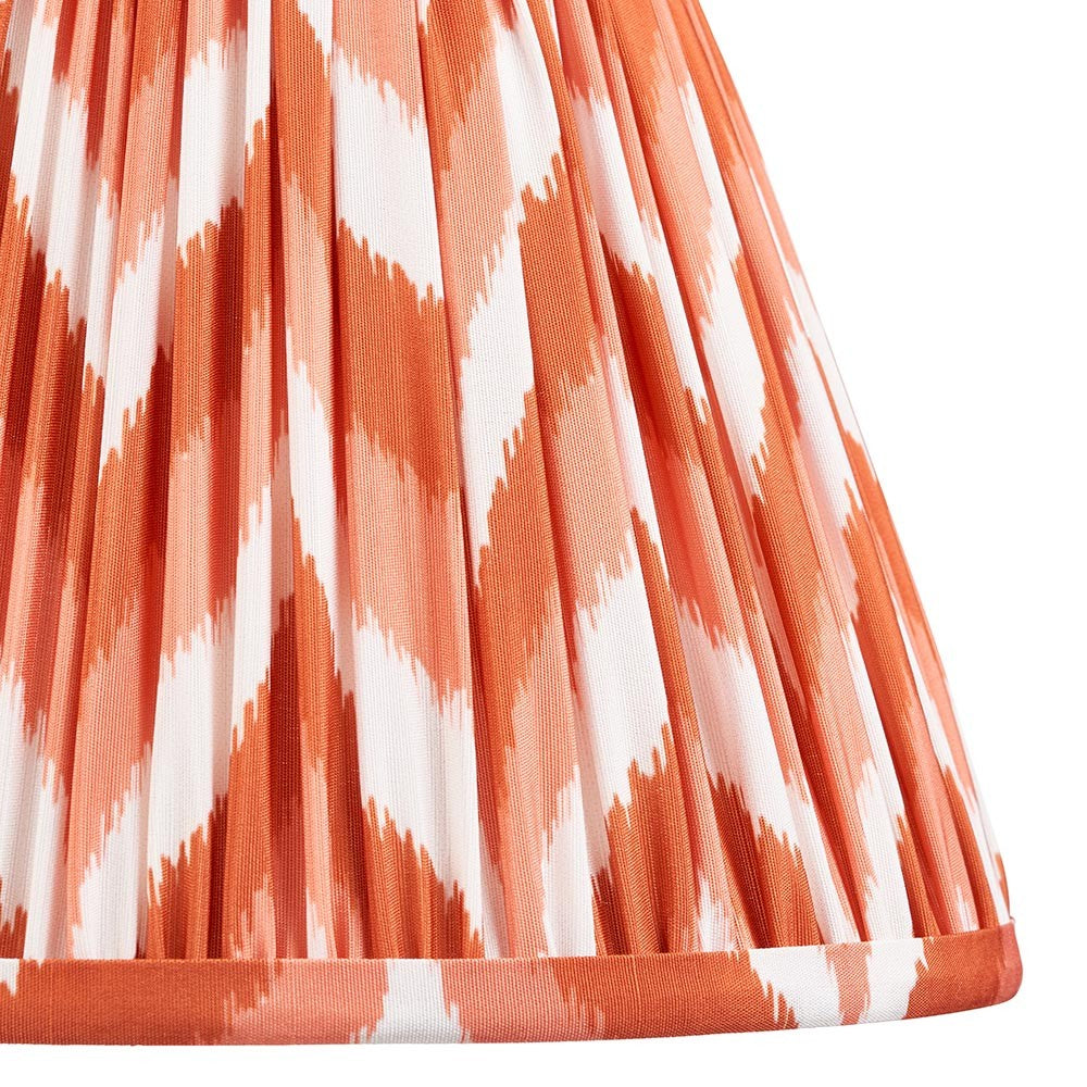 Close-up of Endon Daneton 25cm tapered lamp shade in apricot orange and white, showing pleated faux silk with a zigzag print and taped edge trim.