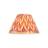 Endon Daneton 30cm tapered lamp shade in pleated apricot orange faux silk with a white zigzag print and taped edges, on a plain background.