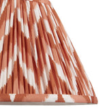 Close-up of Endon Daneton 30cm tapered lamp shade in pleated faux silk with an apricot orange and white zigzag print and taped edge detailing.