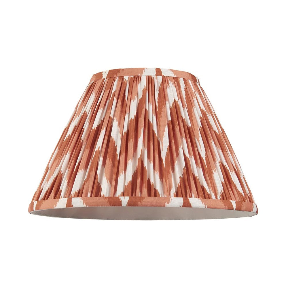 Endon Daneton 30cm tapered lamp shade in pleated faux silk with an apricot orange and white zigzag print and taped edges, on a white background.