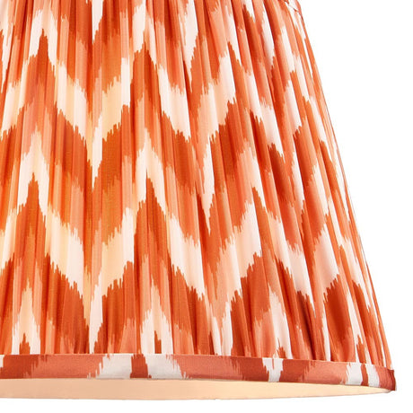 Endon Daneton 35cm tapered lamp shade in apricot orange and white, close-up of the pleated faux silk with a zigzag ikat print and taped hem.
